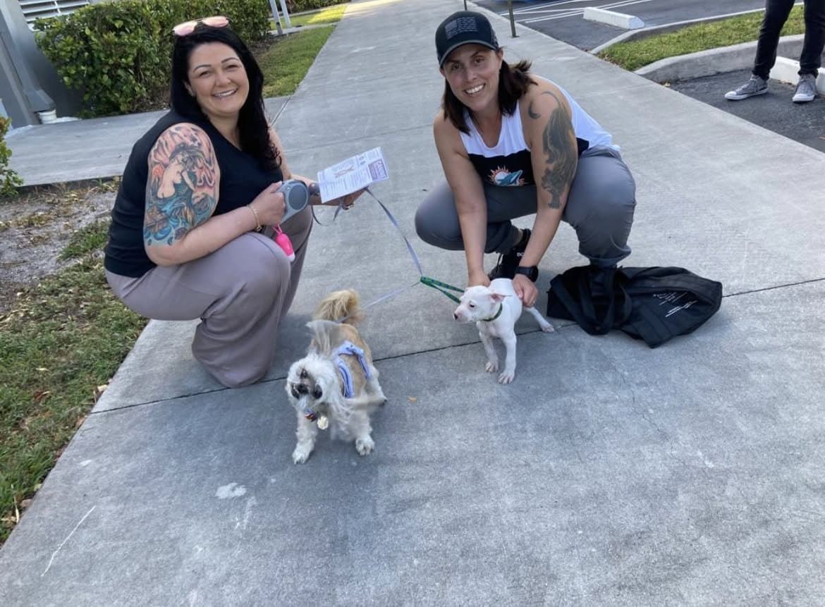 Momma and The Other Momma crouched on the sidewalk with Paris and puppy Misty on pickup day.