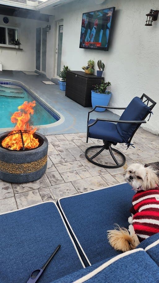 Paris in her red sweater out by the fire pit and pool
