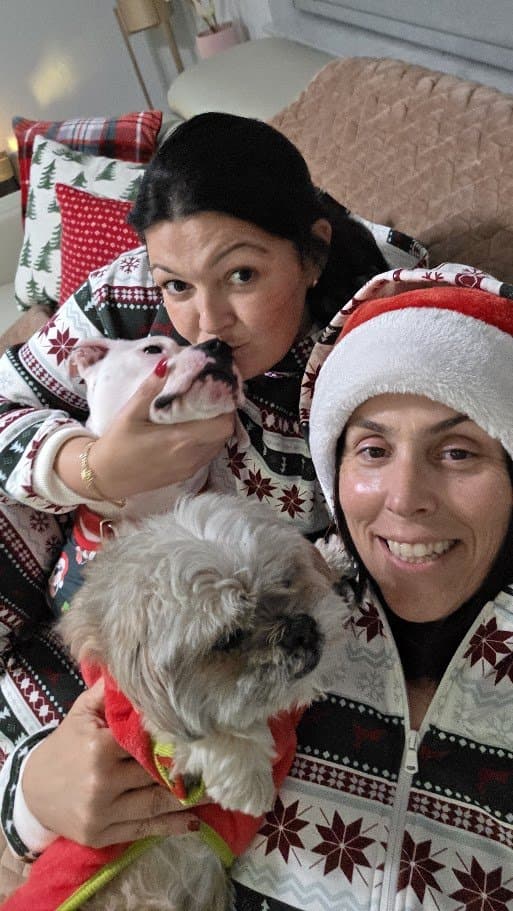 Momma and The Other Momma in Christmas pajamas cuddling Paris and Misty.